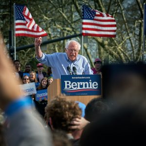 man standing on lectern surrounded by people